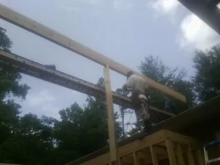 Carpenter setting a ridge beam over a new addition frame — Ice Dam Removal by Roofing Brothers in Vancouver