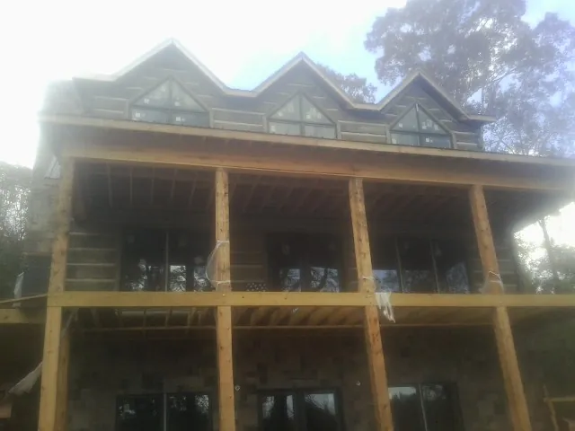 Dormers and porch framing on a large log home under construction — Roof Coating work by our crew in Vancouver
