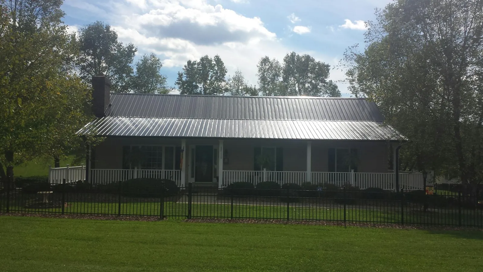 Gray metal roof on a brick ranch with a full width front porch — Gutter Guard Installation work by our crew in Vancouver